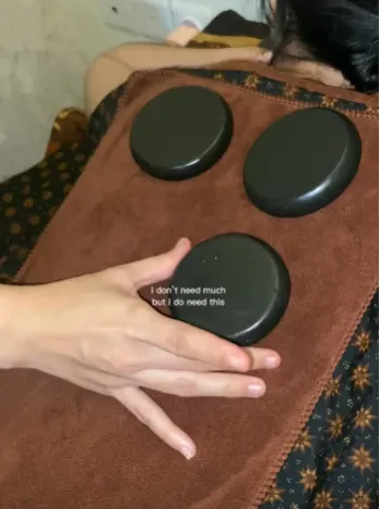 Sampul video Instagram: batu basalt hangat diletakkan di atas handuk di punggung tamu